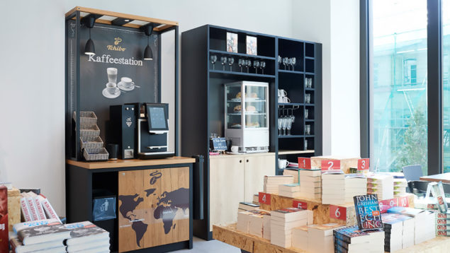 Kaffeeautomat vor Bücherstapel mit Teeküche